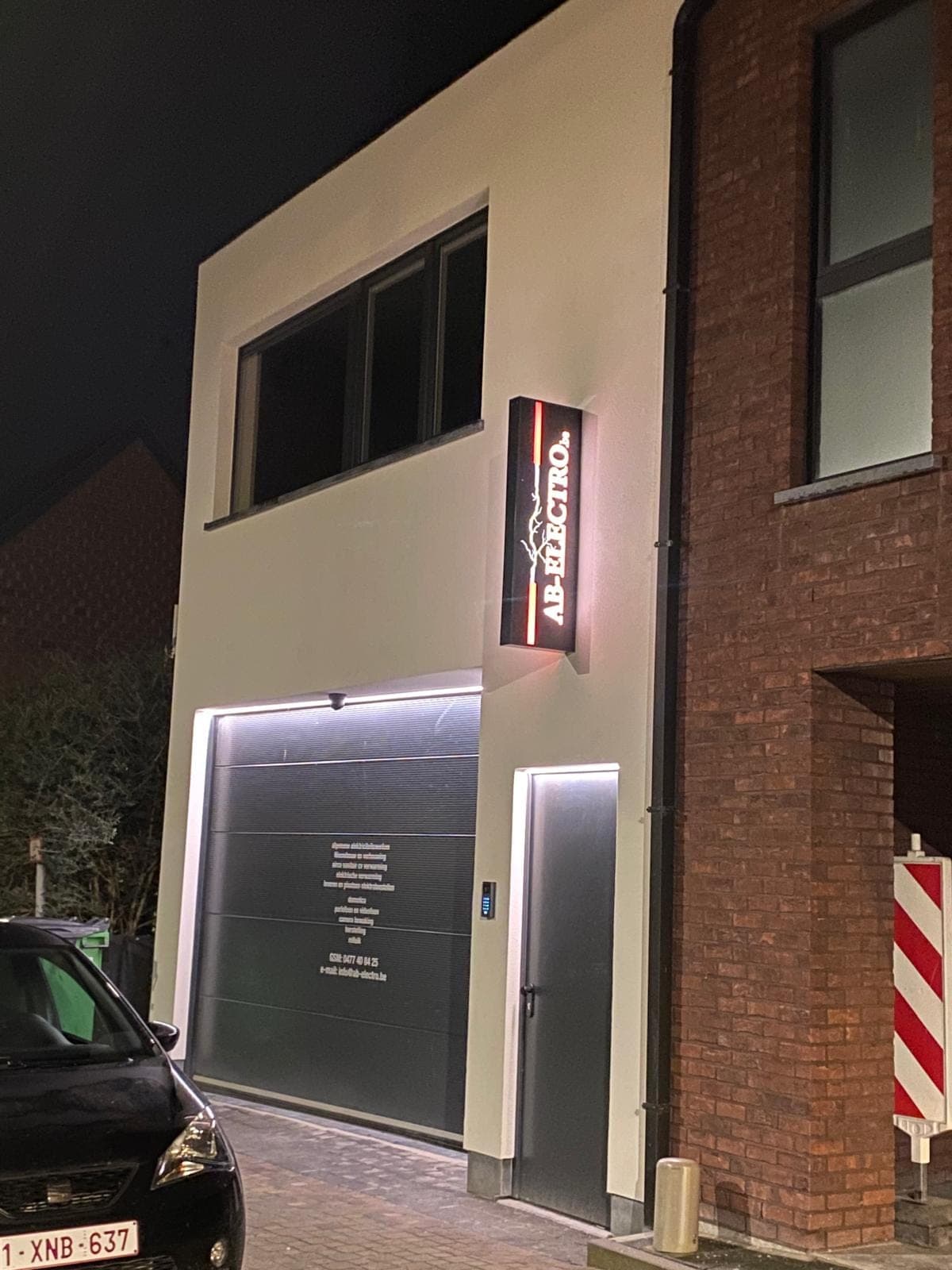 The AB-Electro premises in Aalst with its illuminated sign at night